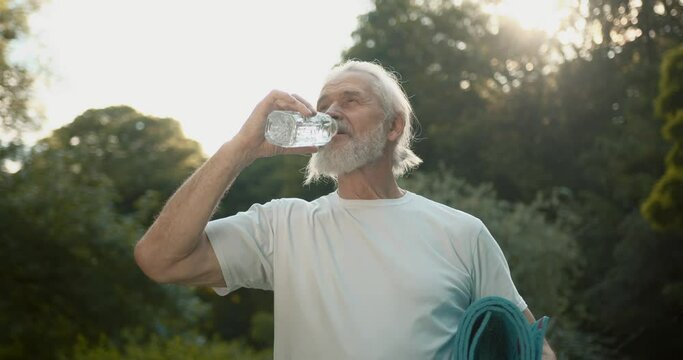 Healthy senior man drink water after practice yoga