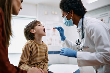 Little boy getting PCR test at doctor's office during virus pandemic.