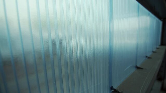Vertically installed hollow polycarbonate panels. Light blue colored translucent walls with wooden frame. Modern plastic material for construction closeup