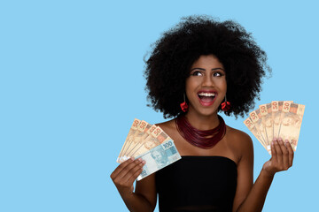 woman smiling holding brazilian money bills, positively surprised, space for text, person,...