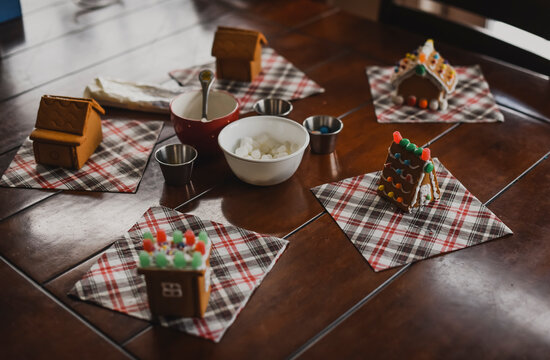 Gingerbread houses ready for decorating with icing and candies.