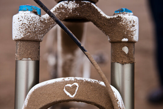 Mountain bike suspension fork with heart drawn in dust