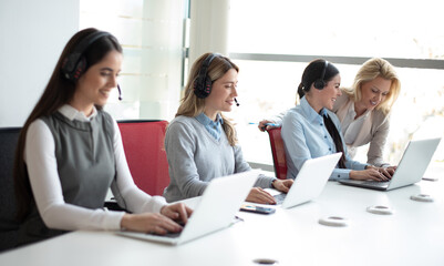 Customer services agents with headset working in a call center.