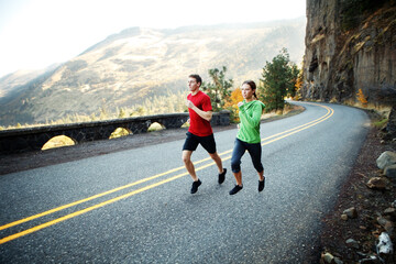Two runners in their mid 20s running along scenic road in Rowena