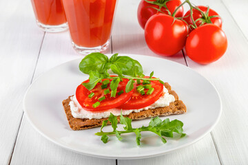 Crispbread with curd cheese, tomatoes, green onions, arugula and basilica. Delicious and healthy breakfast