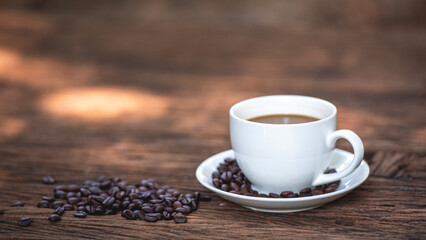 Banner of black drip coffee in ceramic cup on old wood table with coffee bean. Barista serve cup of hot black coffee on old wooden table cafe shop in garden with coffee bean.