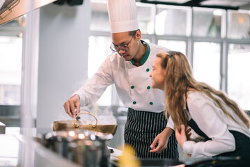 Mature asian teacher teaching schoolgirl chef students to cooking in class. Mature chef with kids at school.