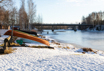 Colourful small boats by icy river