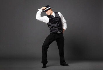 Confident young man dancing in gangster style suite.