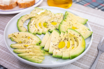 ripe avocado pulp cut into pieces sprinkled with lemon juice on a plate