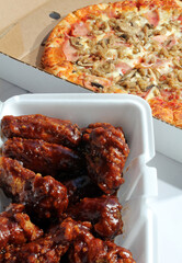 A take-out order of pizza and wings.