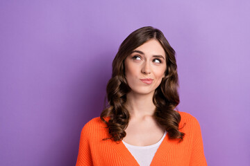 Fototapeta premium Photo of young minded smart woman wavy hairstyle choosing look empty space advertisement unsure about price offer isolated on purple color background