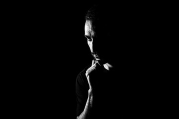 Portrait of a man in a low key. Male face silhouette on black background