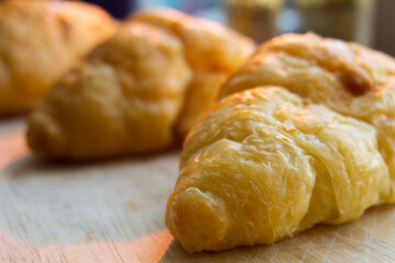 Closeup of pile of delicious croissants. Fresh fragrant homemade bread on the table in the kitchen at home. Food concept