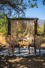 Spot for wedding ceremony with table, two chairs and arch in a zen garden in the mountains in a sunny day