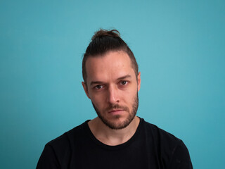 Serious White Man Looking at the Camera on a Turquoise Background