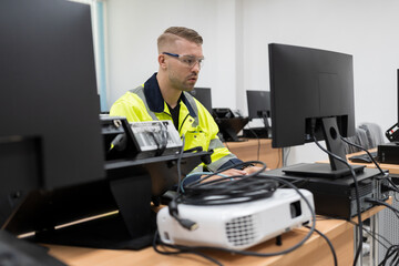 Male engineer working with desktop computer for training Programmable logic controller in the laboratory. Software engineering concept