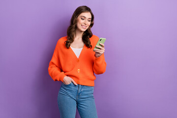 Photo of positive stunning lady wear orange stylish clothes hold modern telephone promoting device shop isolated on purple color background