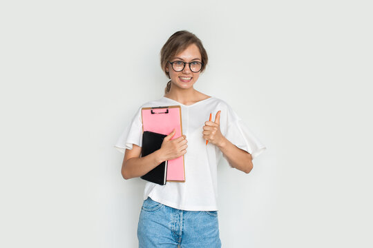 Photo of young positive smile female student showing thumb up gesture while approving education against white background.
