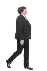 Mature business woman in a pantsuit striding forward.