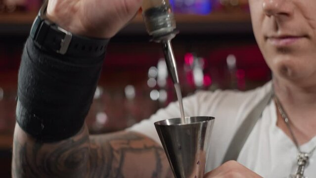 Close-up of a bartender pouring alcohol from a bottle into a glass. Preparation of cocktails for a party in a bar. High quality 4k footage