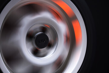 long exposure photography in motion spinning car titanium rims in blurry light	