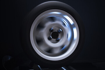 long exposure photography in motion spinning car titanium rims in blurry light	