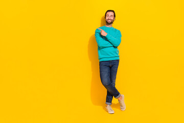 Fototapeta na wymiar Full length photo of funny thoughtful man wear turquoise clothes pointing finger empty space isolated yellow color background
