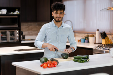 Hispanic man cooking healthy salad in his kitchen - Young man at home making healthy recipes