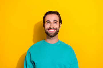 Obraz premium Photo of young cheerful good mood smile brunet hair stubble guy wear blue sweater smile look up cheap prices isolated on yellow color background