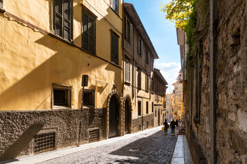A picturesque narrow alley leading to the historic medieval old town walled Città Alta district, in the city of Bergamo, Italy, in the Lombardy region.	