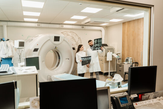 CT scan doctors are discussing x-ray of computed tomography of brains of patient. Computed tomography doctors are consulting and discussing x-ray of patient.