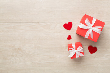 Gift boxes with hearts on wooden background, top view