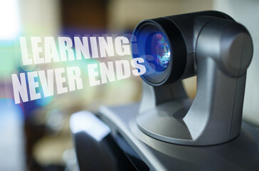 A blue beam glows from the projector inside which is the inscription - Learning Never Ends