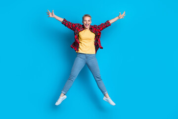 Fototapeta na wymiar Full body size cadre of young overjoyed jumping carefree positive blonde short hair girl star symbol raise hands isolated on blue color background