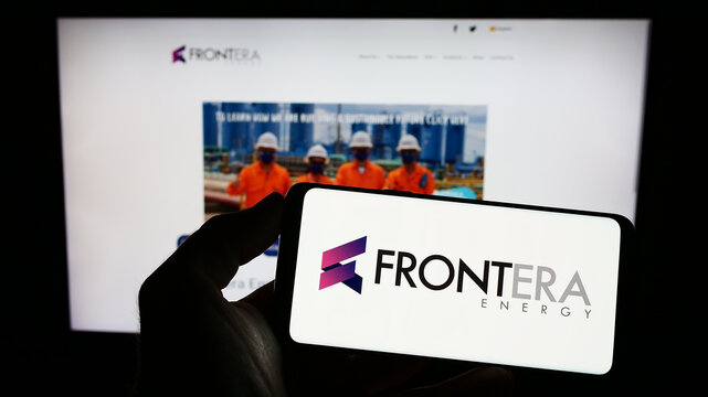 Stuttgart, Germany - 01-27-2023: Person holding mobile phone with logo of Canadian company Frontera Energy Corporation on screen in front of web page. Focus on phone display.