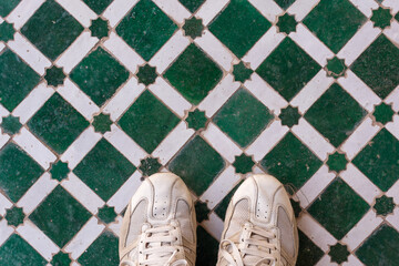 Scenic view of man sport shoes on colored tiles pattern in Marrakesh touristic spot in Morocco
