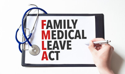 Doctor holding a pen and card with text family medical leave act, medical concept