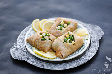 Delicious ruddy pancakes with fresh onions and egg on a wooden background