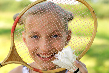 European girl with blue eyes with a badminton racket smiling. Active rest in summer. Summer vacation concept