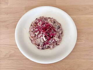 Red chicory risotto on white plate.