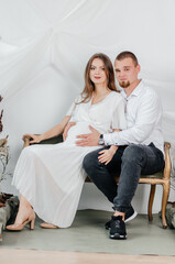 pregnant woman in a white dress with a man