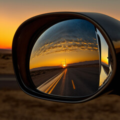 Rearview mirror of a car during sunset. Generative AI.	
