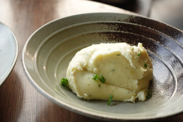 Mashed potatoes in bowl on wooden rustic table