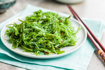 Green seaweed. Japanese wakame salad on plate.