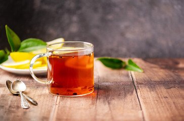 Black tea in glass cup on wooden table with copy space. 