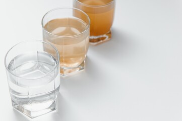 Filter system for water treatment with glasses of clean and dirty water on bright background