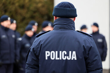 Zimowy mundur policjanta z napisem policja na plecach.  - obrazy, fototapety, plakaty