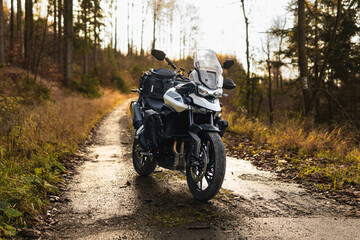 Triumph Tiger motorcycle on the forest road in mountains