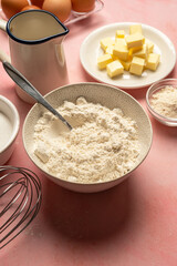 Close up flour in bowl with baking tools and ingredients. Sugar, milk, butter, eggs.